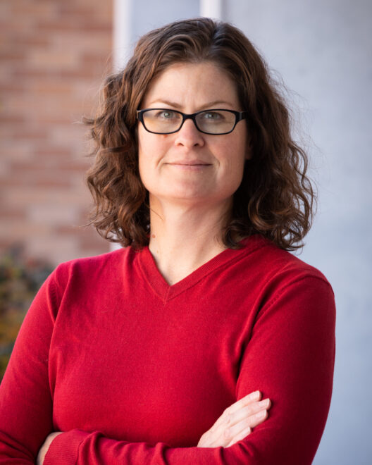 Jennifer Weidhaas in a red shirst against a blurred outdoor background