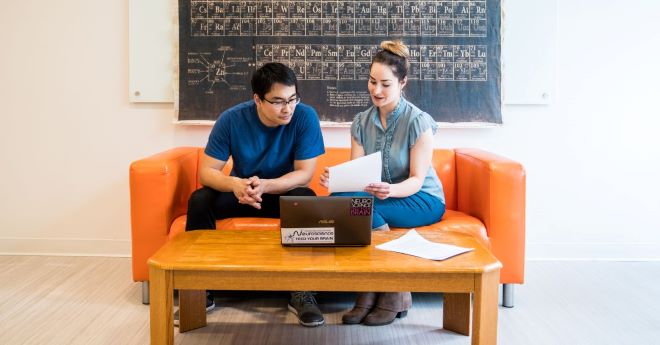 A student goes over flowcharts with an advisor.